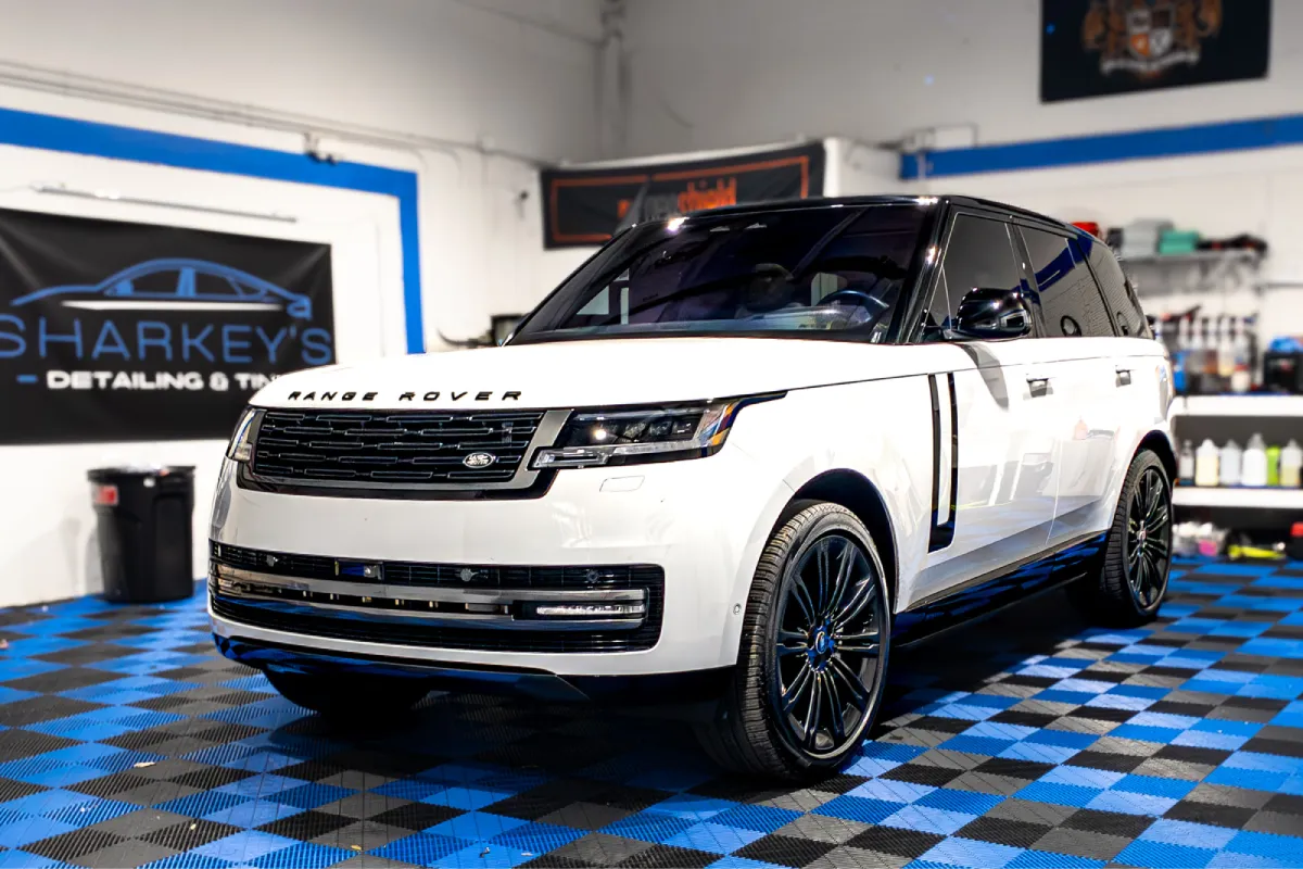 White Range Rover inside auto detailing and tint shop.
